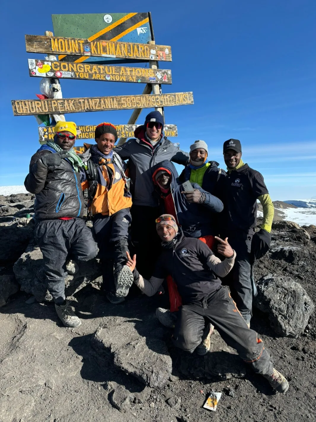 Sean Burgess with part of the Tanzanian guide team at the Uhuru Peak sign